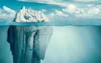 Iceberg in a calm ocean, small bit above water, much larger portion below